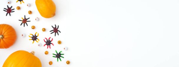 Overhead Halloween Banner Composed Of Pumpkins With Candy Spiders And Eyeballs On White Background - Фото, изображение
