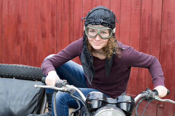 Фото девушки на винтажном мотоцикле в пилотной кепке - Фото, изображение