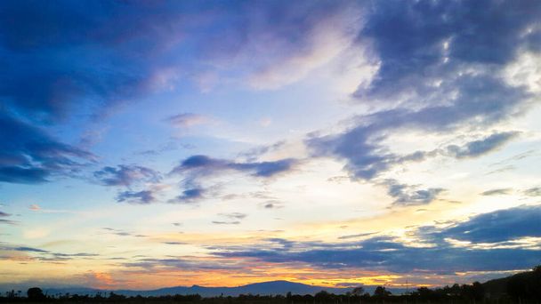 Blauwe lucht met wolken en zonsondergang achtergrond - Foto, afbeelding