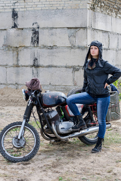 The post Apocalyptic nainen lähellä moottoripyörän lähellä tuhoutunut rakennus - Valokuva, kuva