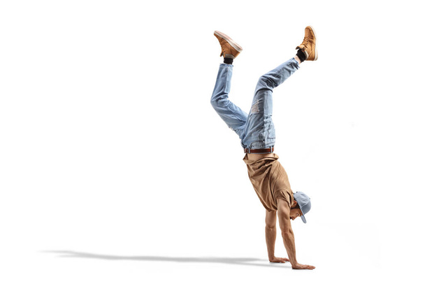 Guy in jeans performing a hand stand isolated on white background - Fotografie, Obrázek