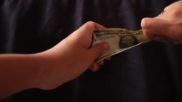 1ドル札をつかむ2つの手は、コヴィド-19パンデミックによる経済的不況、金融危機、破産の概念を示しています - 映像、動画