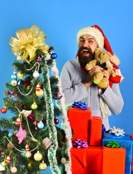 Guy en chapeau rouge avec boîtes cadeaux de Noël et ours - Photo, image
