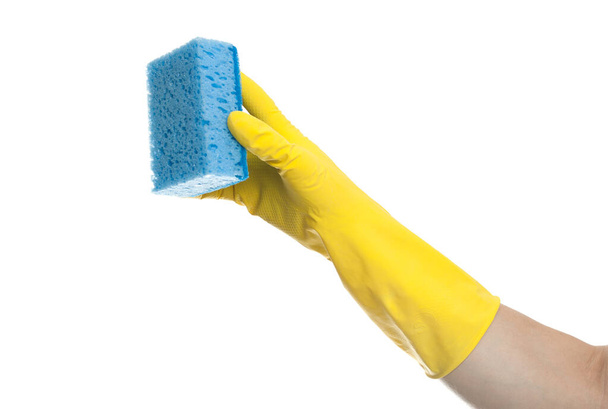 A hand in a yellow rubber glove holds a washing sponge isolated on a white background. House cleaning concept. - Foto, imagen