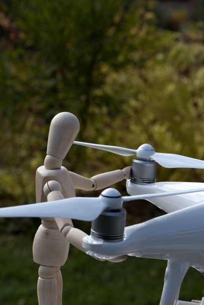 De AI militair pop werkt aan zijn drone. Controle en beproeving van de betrouwbaarheid van propellers voor het vliegen. - Foto, afbeelding