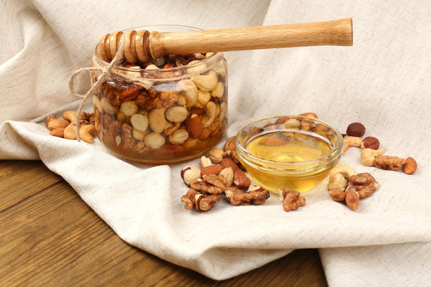 Sweet honey and different nuts on wooden table - Φωτογραφία, εικόνα