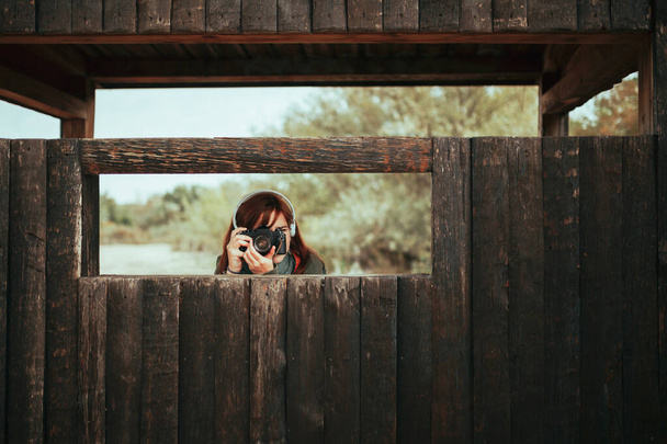 Jeune femme prenant des photos de la cabane en bois dans la forêt - Photo, image