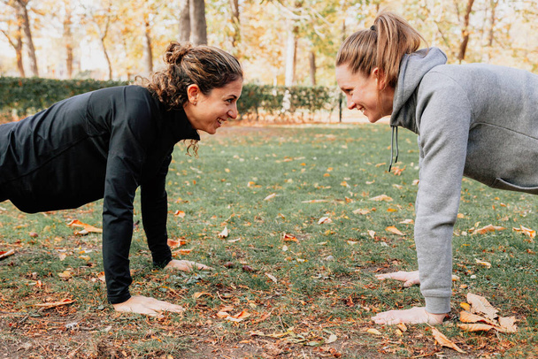 A couple of women training outdoors in the park - Photo, Image