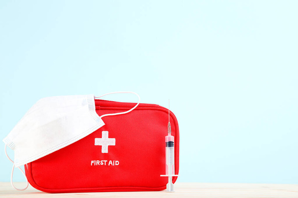First aid kit with syringe and medicine mask on mint background - Φωτογραφία, εικόνα