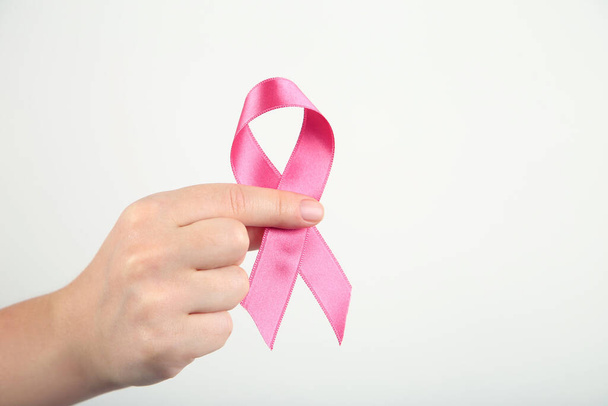 Breast cancer concept. Female hand with pink ribbon - Fotó, kép