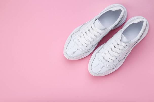 Pair of white shoes on pink background - Valokuva, kuva