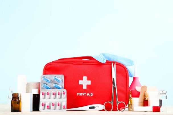 First aid kit with medical supplies on mint background - Φωτογραφία, εικόνα