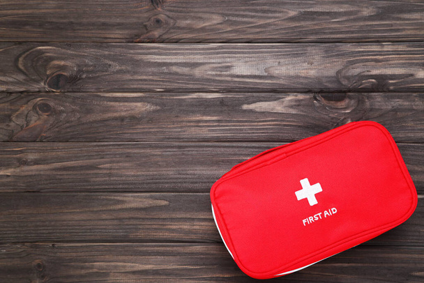 First aid kit on brown wooden background - Fotoğraf, Görsel