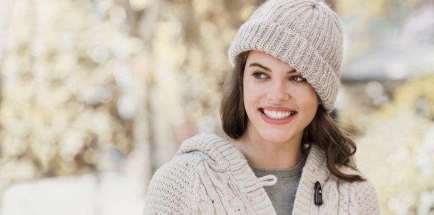 Beautiful joyful woman autumn portrait. Smiling student girl wearing warm clothes and hat in a city in winter panoramic banner - Fotoğraf, Görsel