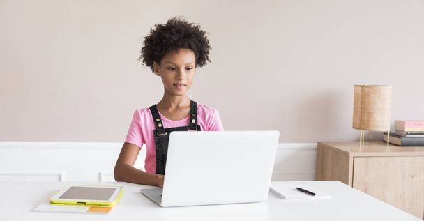 Little girl using laptop at home, child working online on computer indoor, Children lifestyle, distance education, studying at home, technology, people concept - 写真・画像