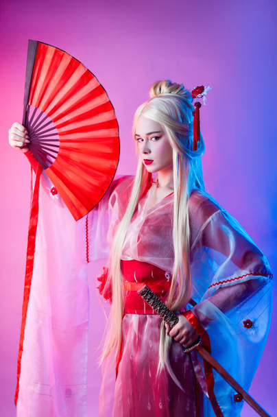 женщина в костюме гейши с катаной и веером - Фото, изображение