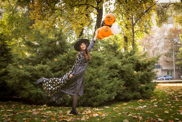 Halloween van. Gyönyörű fiatal nő ünnepi hangulatban egy Halloween-i pikniken. Meleg őszi októberi nap. Érzelmi koncepció. - Fotó, kép