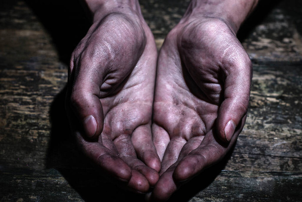 Mies likainen työntekijä kädet pyytävät kämmenet likainen puinen tausta. Avun, kerjäämisen ja köyhyyden käsite. Jaa toivo - Valokuva, kuva