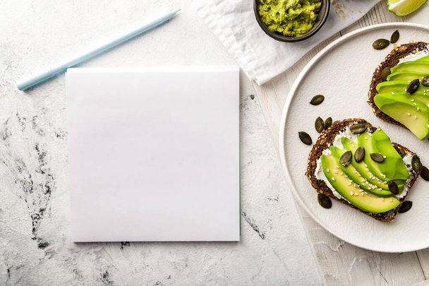 Avocado with cream cheese on grain bread on white tray top view with copy space for your text. Recipe. - Fotoğraf, Görsel