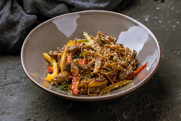 beef wok noodles on black stone table - Zdjęcie, obraz