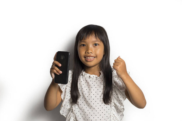 幸せなアジアの女の子使用してスマートフォン上の白い背景 - 写真・画像