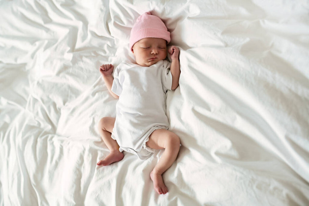 A Sweet newborn baby girl sleeping in white bed - Фото, зображення