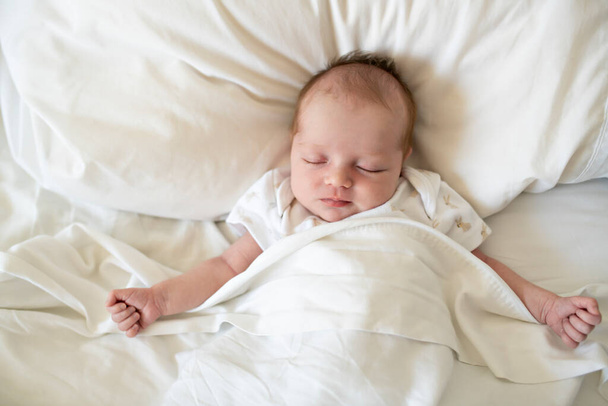 A Sweet newborn baby girl sleeping in white bed - Foto, immagini