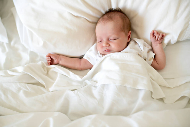 A Sweet newborn baby girl sleeping in white bed - Foto, Imagem