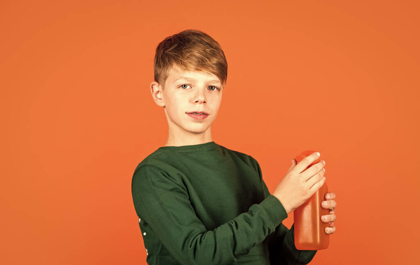 Water balance. Small child drink juice orange background. Little boy enjoy drinking fruit juice. Juice healthy part of kids diet. Juice recipe. Smoothie detox cocktail. Refreshing beverage concept - Foto, Bild