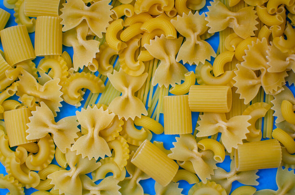 different pasta on a blue background - Fotoğraf, Görsel