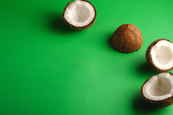 Kokosové ovoce na zeleném prostém pozadí, abstraktní jídlo tropické koncepce, úhel pohledu kopírovat prostor - Fotografie, Obrázek