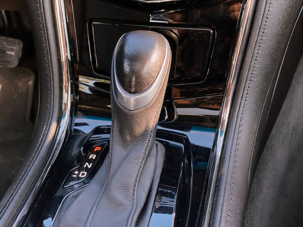 Close-up van de versnellingshendel in de auto. Foto van een auto interieur in het zwart. - Foto, afbeelding