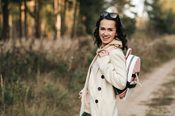 brunette girl with backpack on the forest path - Foto, Imagem