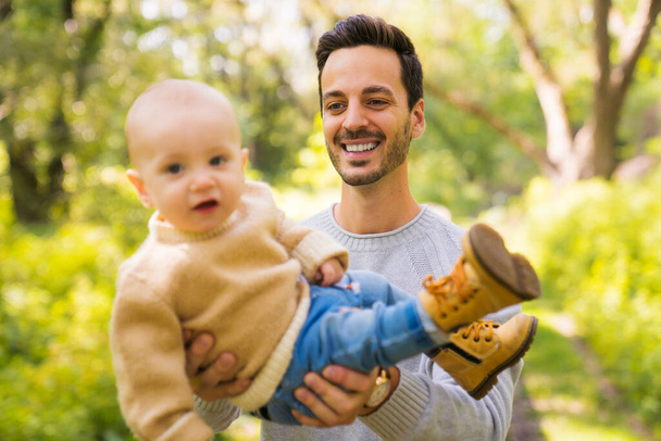 Father and baby having fun in the forest - 写真・画像