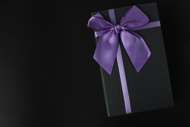 tylko czarny czarny prezent pudełko z fioletowy liliowy fuksja wstążka i łuk na czarnym tle z miejsca na tekst przestrzeń ojciec dzień nowy rok Boże Narodzenie urodziny dla mężczyzn - Zdjęcie, obraz