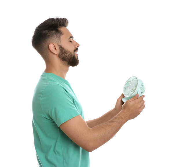 Man enjoying air flow from portable fan on white background. Summer heat - Photo, image