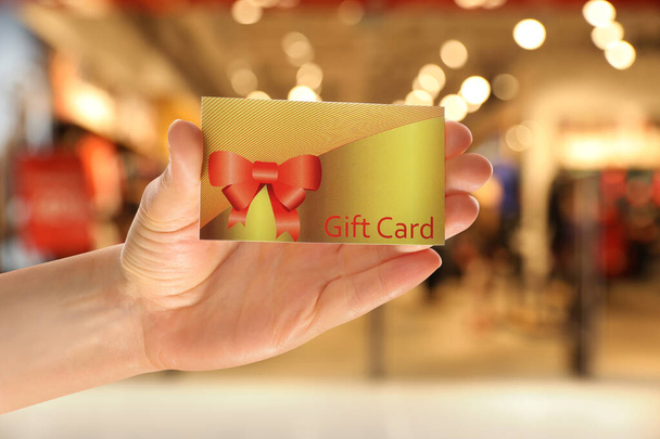 Woman holding gift card in shopping mall, closeup - Φωτογραφία, εικόνα
