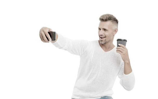 Good mood. Enjoying his coffee. Sharing good news. Mobile communication. Drink it on the go. Coffee take away. Mature man hold paper coffee cup stand white background. Delicious fresh coffee concept - Фото, зображення