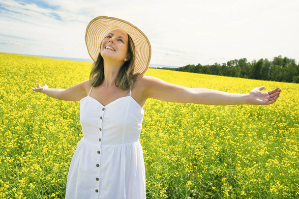 beautiful young happy woman on rapeseed field in bloom - Foto, Imagem