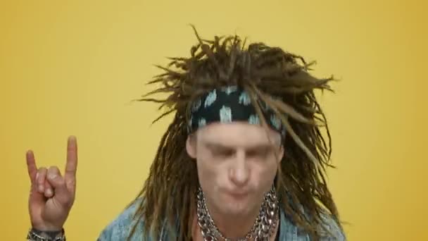 Crazy rocker dancing in studio. Man waving head on yellow background - Footage, Video