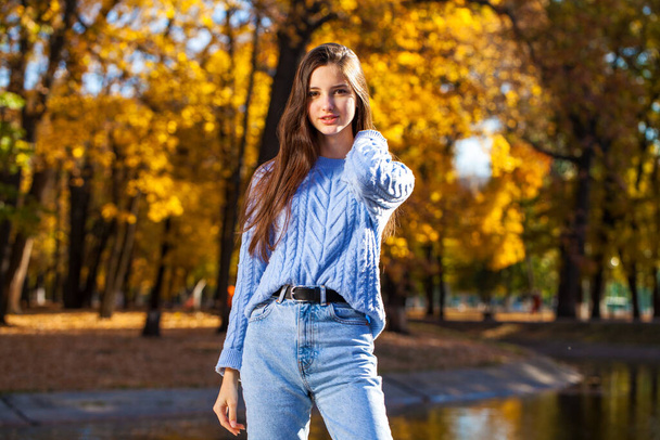 Close up portrait of a young girl in blue sweater, autumn park outdoor - Foto, Bild