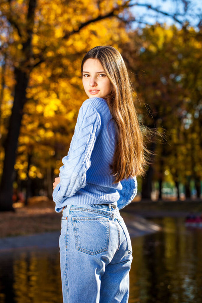 Close up portrait of a young girl in blue sweater, autumn park outdoor - Foto, imagen
