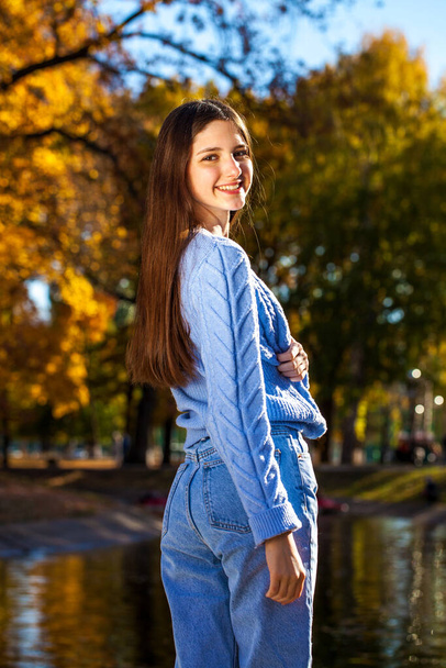 Close up portrait of a young girl in blue sweater, autumn park outdoor - Foto, Imagen