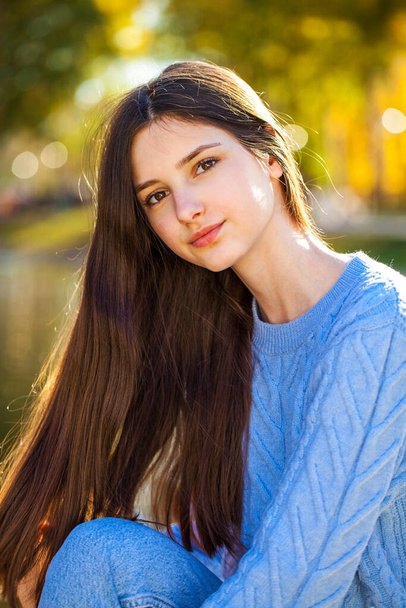 Close up portrait of a young girl in blue sweater, autumn park outdoor - Foto, afbeelding