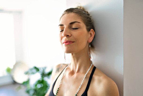 Nice yoga teacher woman in a studio indoors - Fotografie, Obrázek