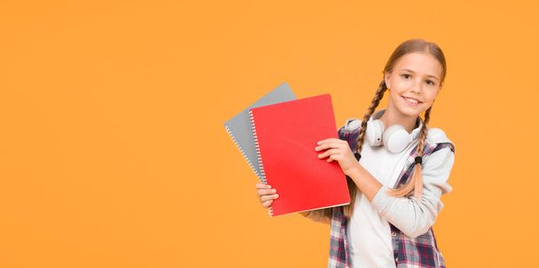 back to school. use notebook or book. Study lessons for exam. find inspiration in book. Enjoying study. Confident in her knowledge. small kid in headset with notepad. child ready to study - Photo, Image