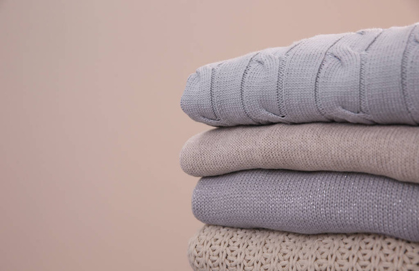 Stack of folded warm sweaters on grey background, closeup. Space for text - Foto, Imagem