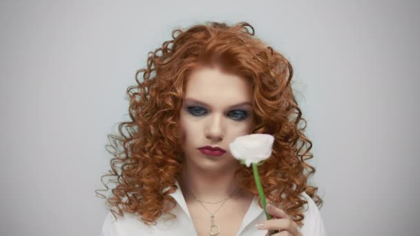 Une fille tenant une rose blanche à la main. Triste femme imitant horloge flèche avec fleur - Séquence, vidéo