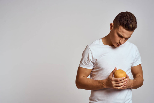 A man with an orange and a white t-shirt on a light background cropped view of the model - Foto, immagini