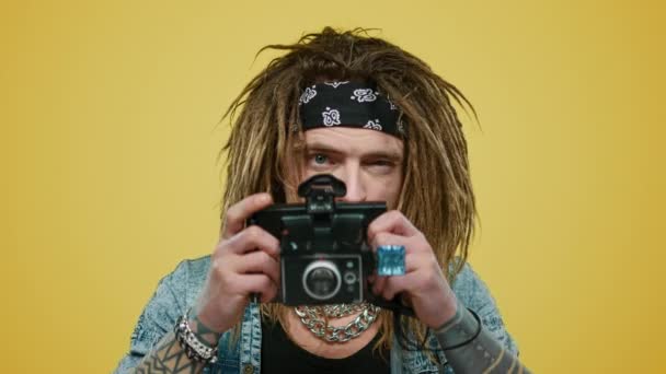 Ο άνθρωπος που τραβάει φωτογραφίες στην παλιά φωτογραφική μηχανή. Χαμογελώντας τύπος ποζάροντας στην κάμερα στο στούντιο - Πλάνα, βίντεο